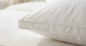 Detail of a high-thread-count cotton cover on a down pillow, highlighting breathability and quality materials.